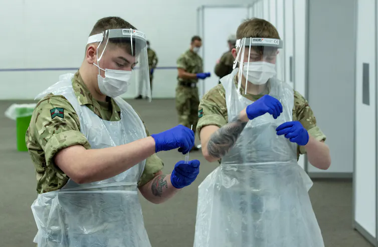 Two soldiers handling tests during mass testing in Liverpool