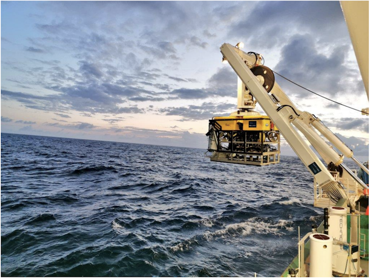 Some yellow equipment lowered from a crane into the sea