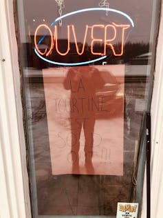 A sign in a window says a shop is sold out of tourtines.