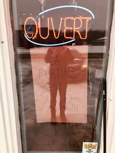 A sign in a window says a shop is sold out of tourtines.