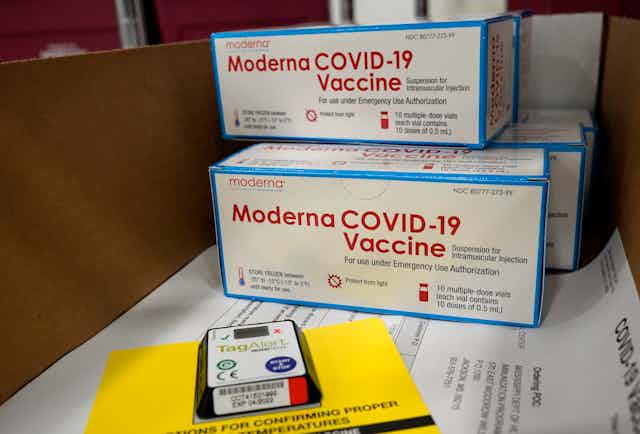 Boxes of the Moderna vaccine sitting on a table.