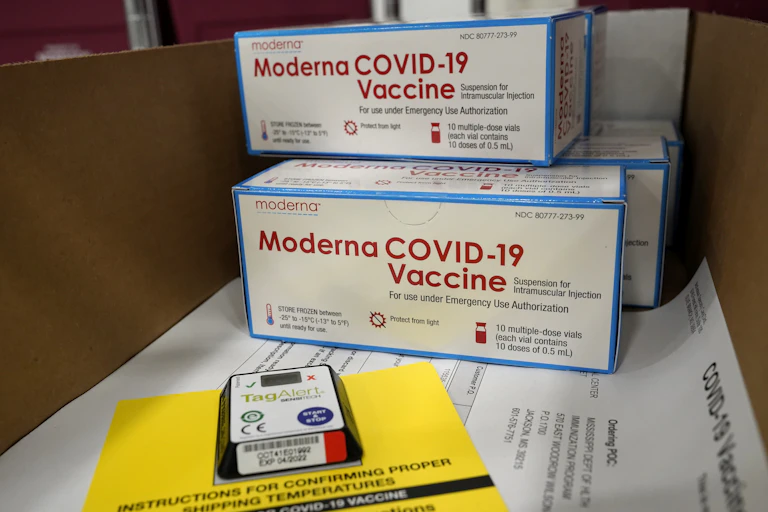 Boxes of the Moderna vaccine sitting on a table.