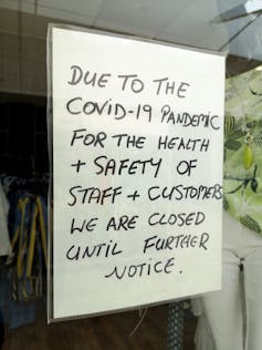 A sign in a shop window saying the shop is closed until further notice due to COVID-19