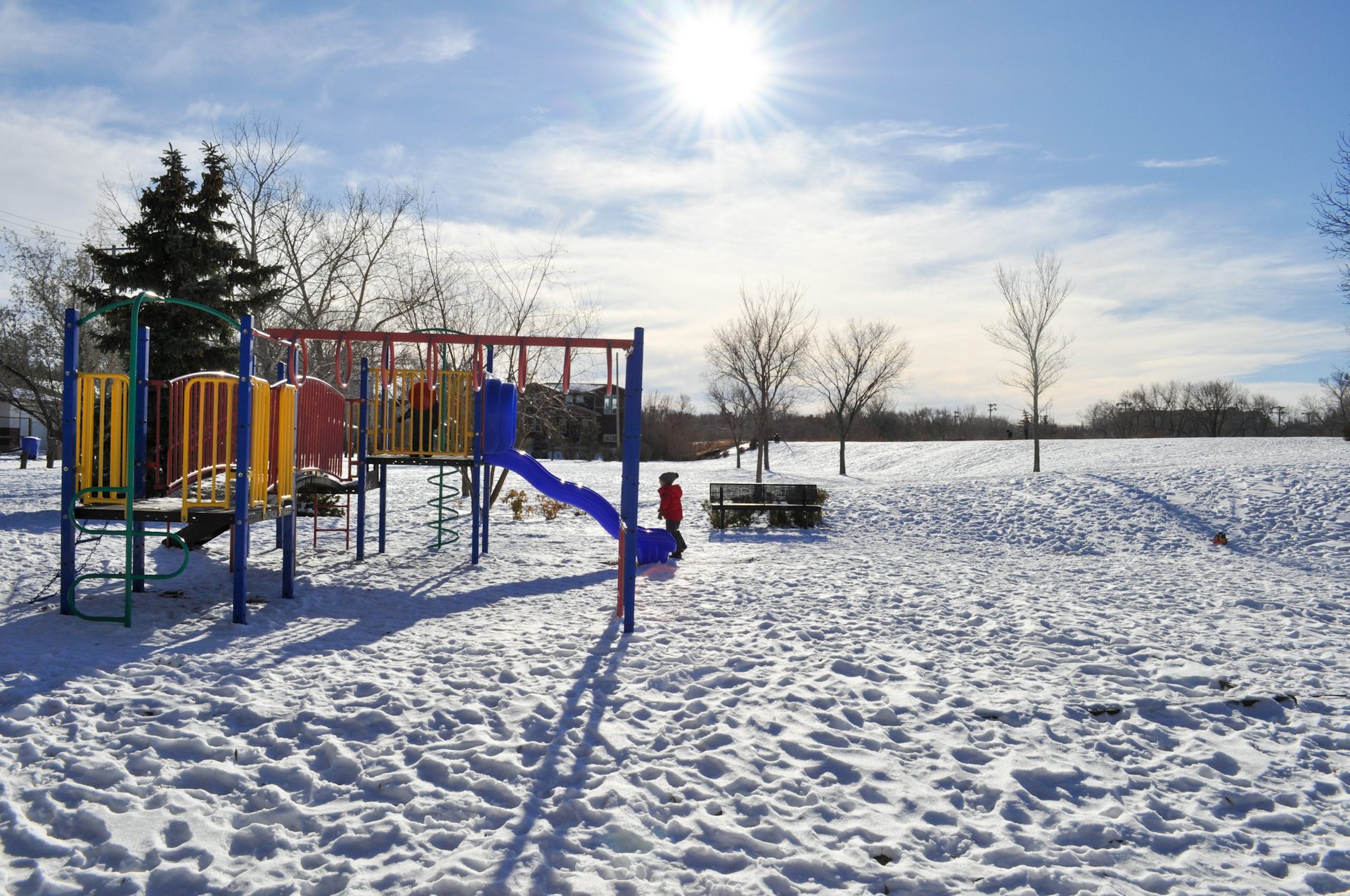 A child at a playground in winter.