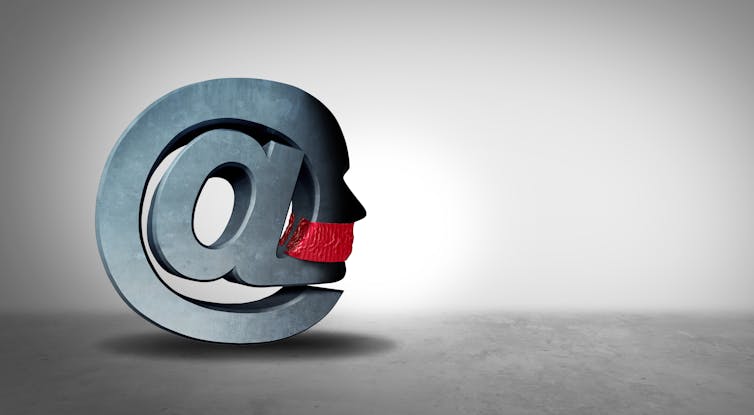 large grey at symbol with a red cloth around the mouth of the face on the side of it