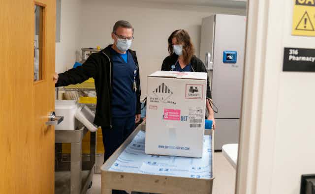Hospital staff with a box of vaccine.