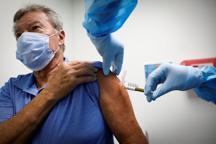 An older man receiving a COVID-19 vaccine