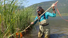A woman kicking muddy water into a net
