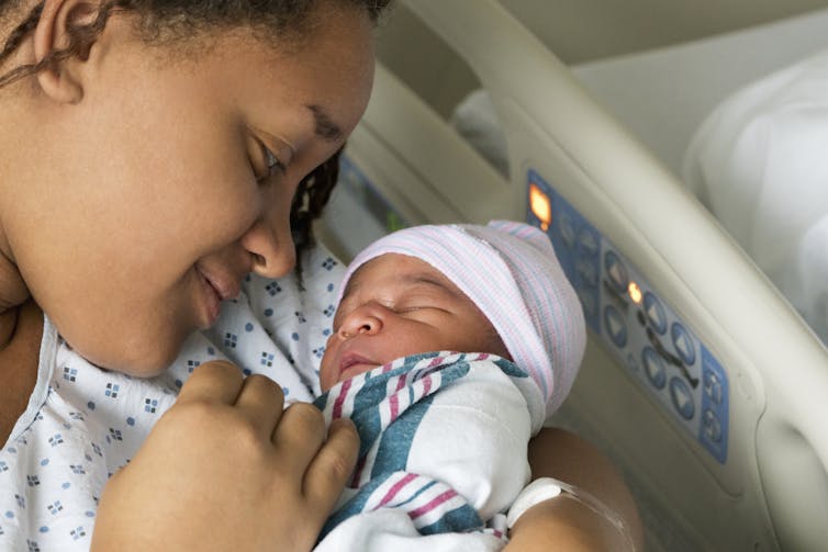 An African American mother looks at her infant child.