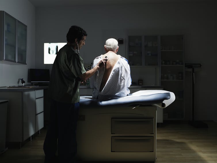 A doctor examines a patient with a stethoscope.