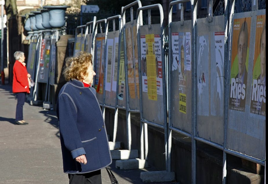 Des personnes regardent les affiches officielles des candidats aux élections cantonales et municipales, le 06 mars 2008 à Strasbourg. 