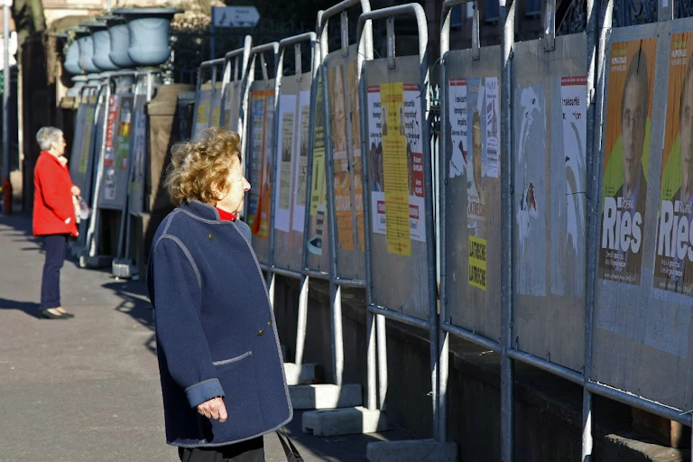 Des personnes regardent les affiches officielles des candidats aux élections cantonales et municipales, le 06 mars 2008 à Strasbourg.