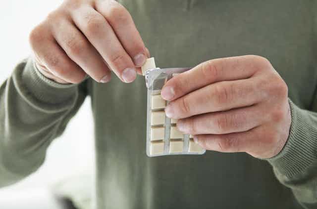 A person removing nicotine gum from a blister pack.