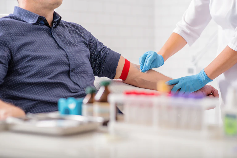 Nurse disinfecting the arm of a patient before taking their blood