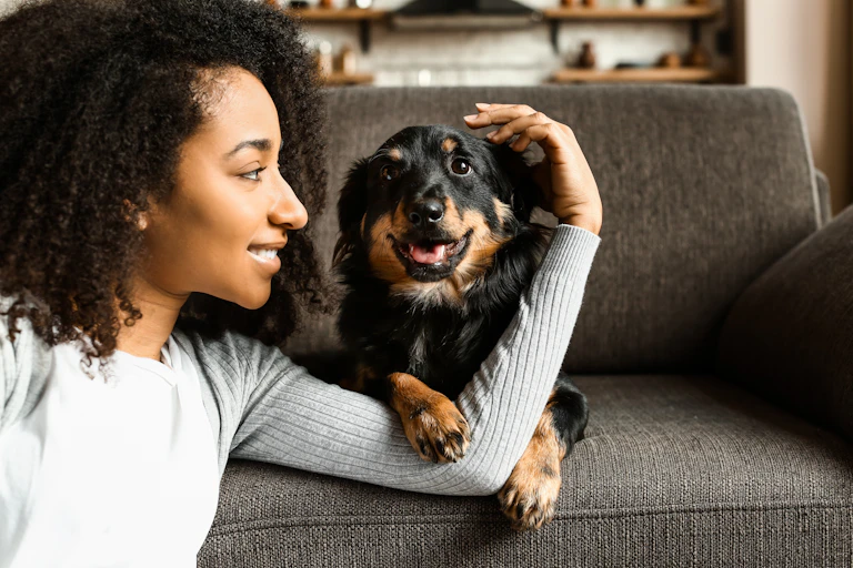 A woman and a dog on a sofa