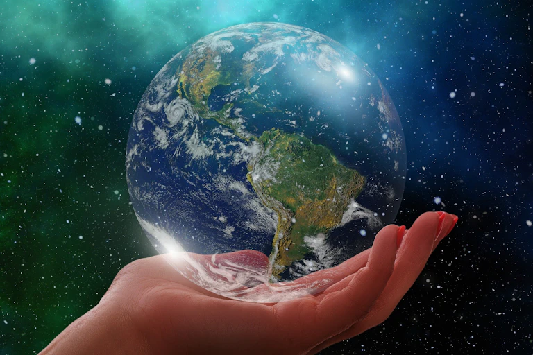 A hand holds a globe.