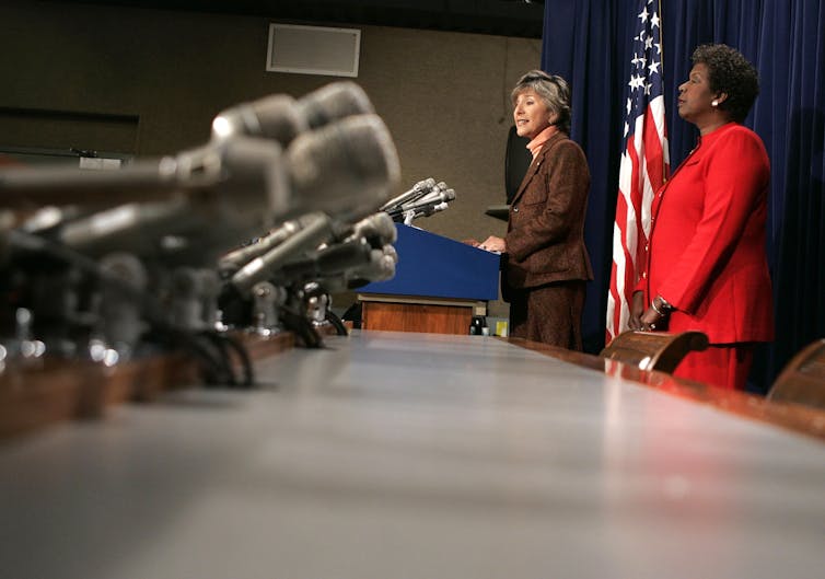 Boxer and Jones in front of a bank of microphones