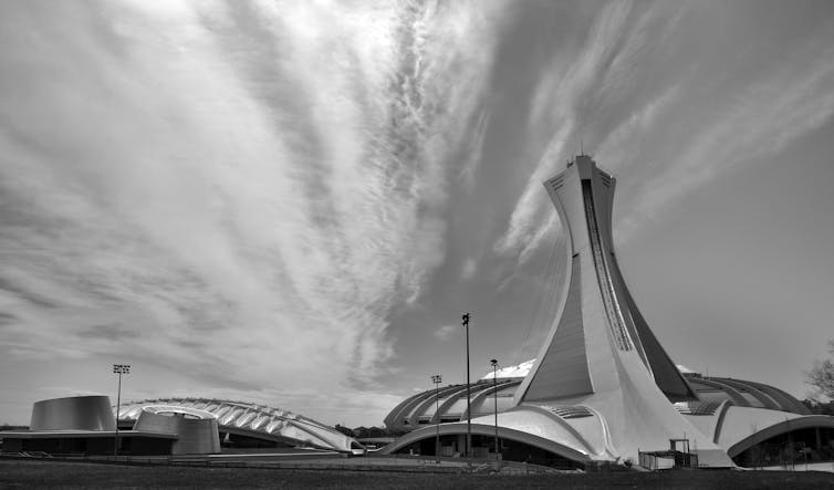 A dramatic black and white photograph of Montréal's Olympic Stadium