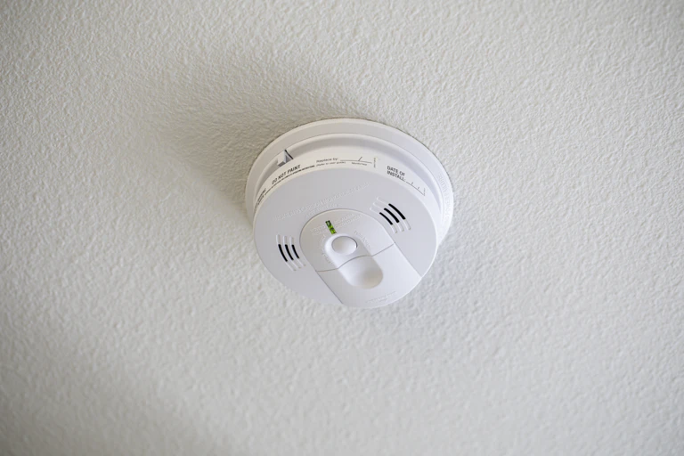 An image of a smoke detector on a ceiling.