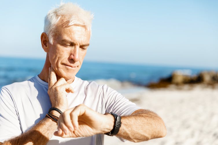 Middle-aged man checking his pulse after exercising. overestimate exercise levels