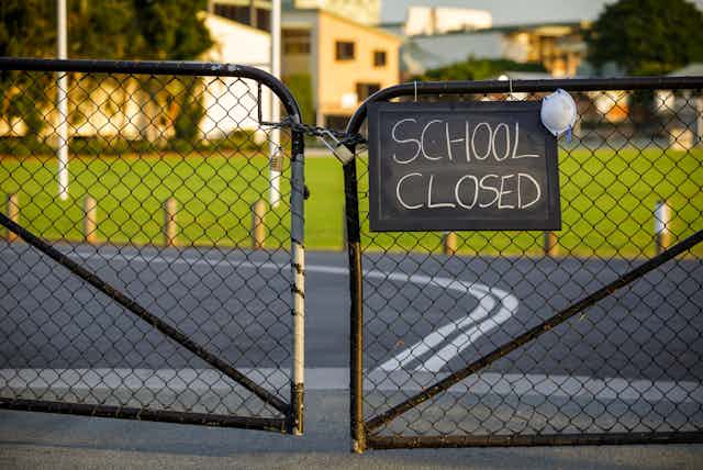 Locked gates with 'school closed' sign