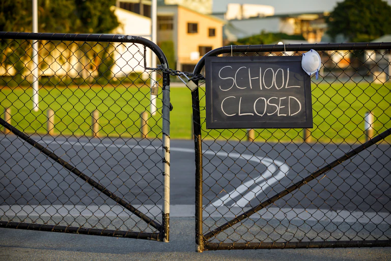 Locked gates with 'school closed' sign