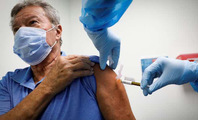 A man receiving a COVID-19 vaccine in the UK