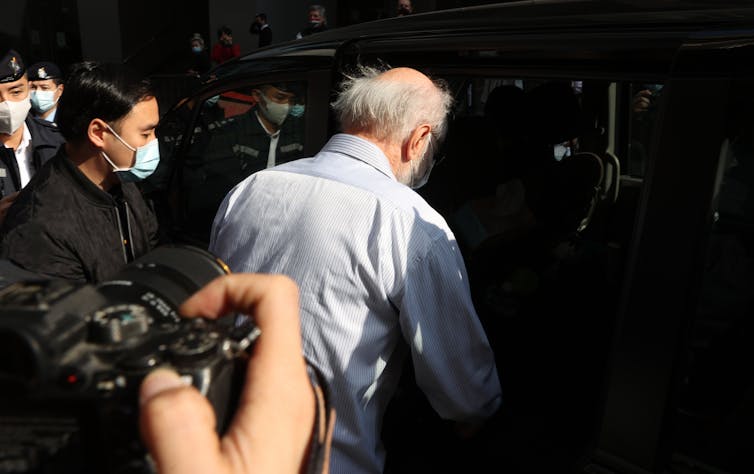 Elderly man being arrested by Chinese security forces in Hong Kong.