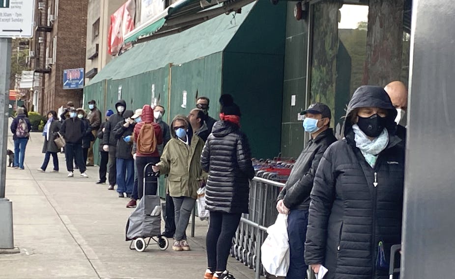 Long line of shoppers waiting to get into Grocery Store, Soci