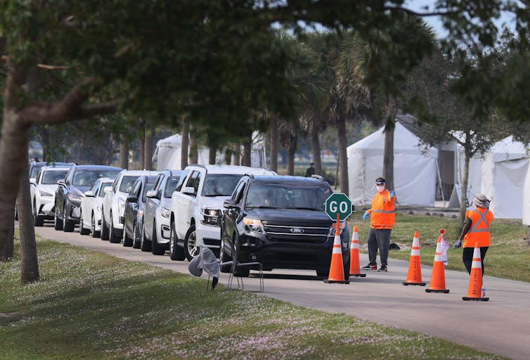 A line of cars at a drive-thru vaccination site.