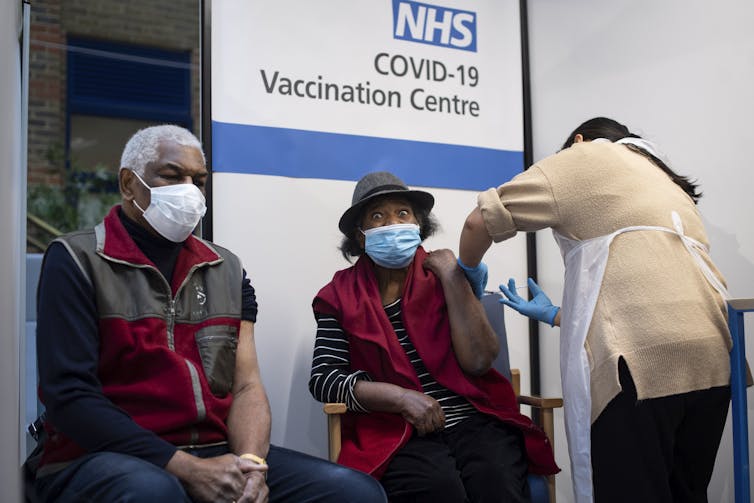Patients receive COVID vaccines at a UK clinic