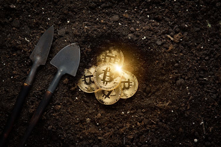 Graphic illustration of bitcoins being mined from a hole