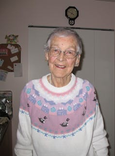 An elderly woman smiling into the camera.