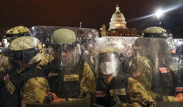 Police in riot gear stand outside the U.S. Capitol