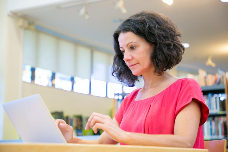 Woman types on a laptop