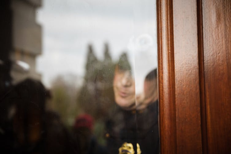 A Capitol Police officer looks out from the Capitol Building at a group of pro-Trump protesters