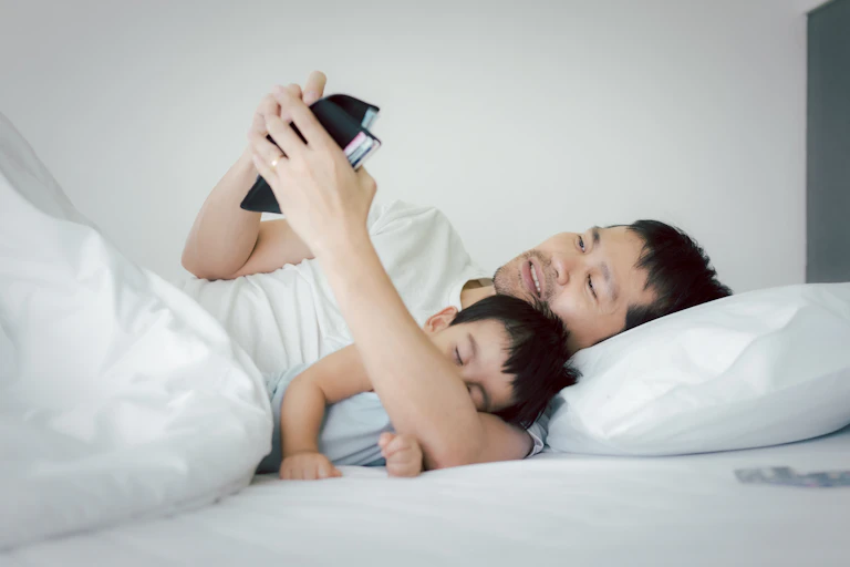 Unemployed stress asian man is hugging his baby on the bed and looking the wallet to find the money to pay for the expense and loan , concept of impact of covid 19 to personal financial problem.