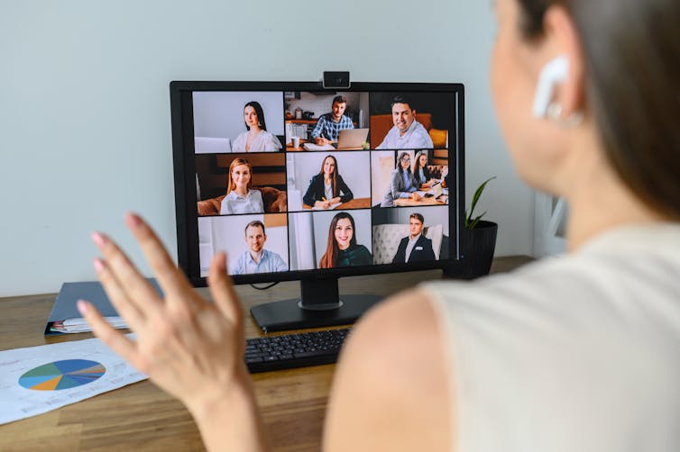 Woman video conferences with others on a screen