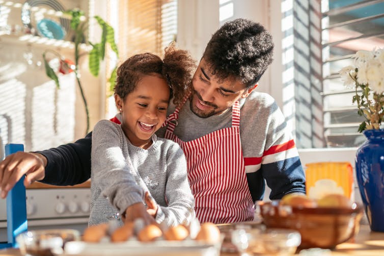 Father and daughter have fun cooking in kitchen