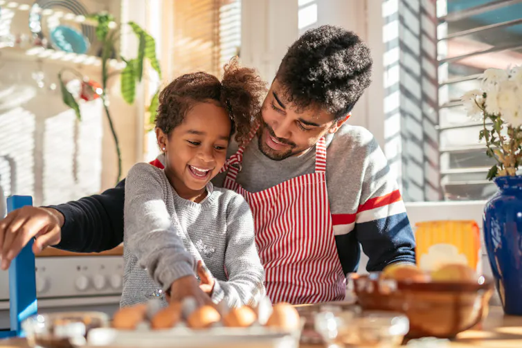Father and daughter have fun cooking in kitchen