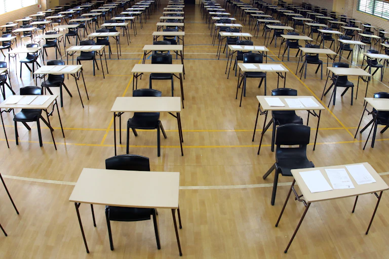 Empty exam hall with tables and chairs