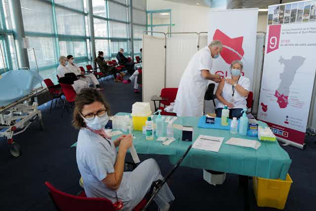 Des personnels médicaux vaccinent dans un centre dédié à la vaccination.