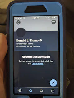 A photo of a smartphone with the screen showing Trump's suspended Twitter account