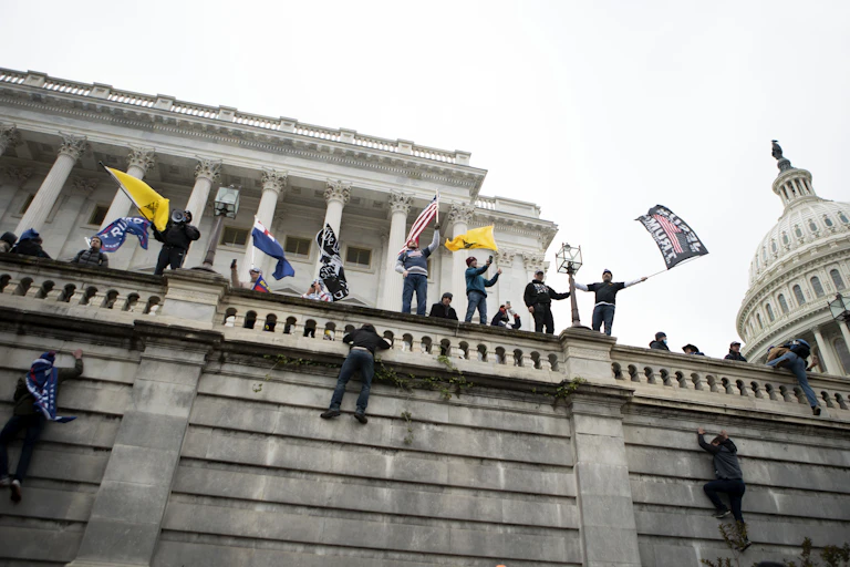 Supporters of U.S. President Donald Trump climb a wall of the the U.S. Capitol