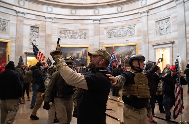 A throng of Trump supporters stand in the U.S. Capitol Rotunda on Jan. 6 as one snaps a picture.