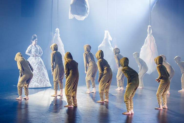 Pamela Rabe in a white ballgown, children in yellow bow.