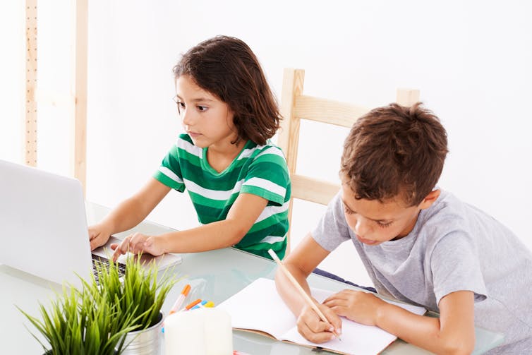 Two children working on homework at table