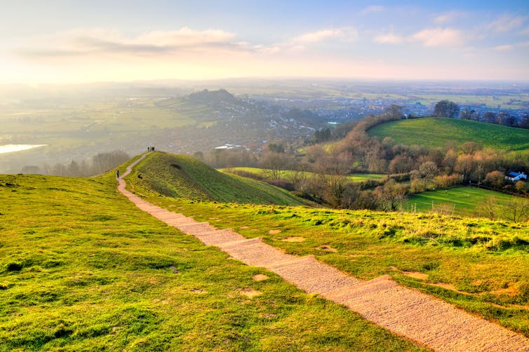 Large green field with path running through it in Glastonbury, UK