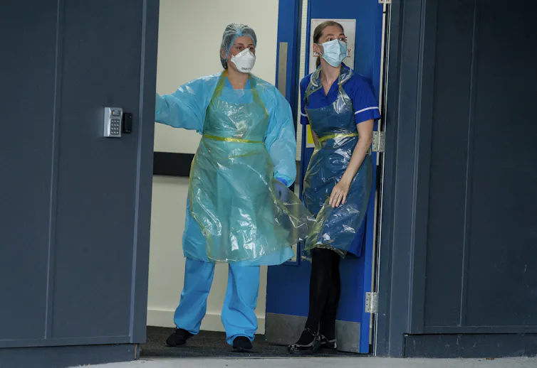 Two hospital staff wearing PPE.