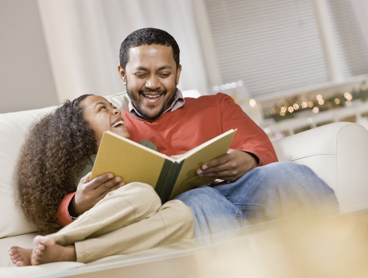 daughter and father reading a picture book